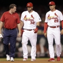 St. Louis Cardinals' Matt Adams, center, walks off the field after being checked on by Cardinals trainer Chris Conroy, left, and manager Mike Matheny after an injury during the fifth inning of a baseball game against the Arizona Diamondbacks Tuesday, May 26, 2015, in St. Louis. Adams left the game after injuring his right leg while running out a double. (AP Photo/Jeff Roberson)