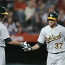 Oakland Athletics' Brandon Moss, right, celebrates his home run with Seth Smith during the fifth inning of a baseball game against the Los Angeles Angels in Anaheim, Calif., Wednesday, April 10, 2013. (AP Photo/Chris Carlson)