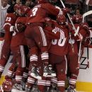 Phoenix Coyotes' Keith Yandle (3) leaps into the celebration as Oliver Ekman-Larsson (23), of Sweden, Daymond Langkow (22), Antoine Vermette (50), Adrian Aucoin (33) and Radim Vrbata (17), of the Czech Republic, surround Ray Whitney after his game-winning goal against the Nashville Predators during overtime of Game 1 in an NHL hockey Stanley Cup Western Conference semifinal playoff series, Friday, April 27, 2012, in Glendale, Ariz. The Coyotes won 4-3. (AP Photo/Ross D. Franklin)