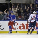 New York Rangers left wing Carl Hagelin (62), of Sweden, and right wing Ryan Callahan (24) celebrate with center Derek Stepan (21) after Stepan scored a goal as Washington Capitals left wing Alex Ovechkin (8), of Russia, skates past them in the third period of Game 4 of their first-round NHL Stanley Cup playoff series in New York, Wednesday, May 8, 2013. The Capitals won 4-3. (AP Photo/Kathy Willens)