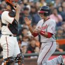 Washington Nationals' Steve Lombardozzi claps his hands as he scores in front of San Francisco Giants' Buster Posey during the first inning of a baseball game, Monday, Aug. 13, 2012 in San Francisco, Calif.  (AP Photo/George Nikitin)