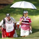 Mika Miyazato, of Japan, and her caddie, Chad Payne, check the line on a putt on the ninth green during the second round of the LPGA Tour's Kingsmill Championship golf tournament in Williamsburg, Va., Friday, Sept. 7, 2012. (AP Photo/Richmond Times-Dispatch, Alexa Welch Edlund)