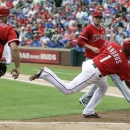 Los Angeles Angels catcher Chris Iannetta (17) and pitcher pitcher Garrett Richards (43) look on as Texas Rangers Elvis Andrus (1) runs in scoring from third base on a wild pitch during the second inning of a baseball game Saturday, Sept. 28, 2013, in Arlington, Texas. (AP Photo/LM Otero)