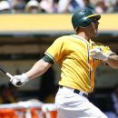 Oakland Athletics' George Kottaras follows through on a two-run home run against the Los Angeles Angels in the second inning of a baseball game in Oakland, Calif., Wednesday, Aug. 8, 2012. (AP Photo/Dino Vournas)