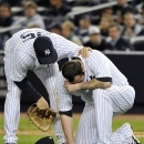 New York Yankees' Mark Teixeira, left, checks on relief pitcher Joba Chamberlain after Chamberlain was hit by a broken bat during the twelfth inning of Game 4 of the American League division baseball series against the Baltimore Orioles, Thursday, Oct. 11, 2012, in New York. (AP Photo/Bill Kostroun)