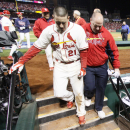 St. Louis Cardinals' Allen Craig is escorted off the field by head trainer Greg Hauck after scoring the game-winning run in the ninth inning during Game 3 of the World Series between the St. Louis Cardinals and the Boston Red Sox on Saturday, Oct. 26, 2013, at Busch Stadium in St. Louis. (AP Photo/St. Louis Post-Dispatch, Chris Lee)