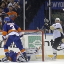 Pittsburgh Penguins right wing Pascal Dupuis, right, reacts after scoring a goal against New York Islanders goalie Evgeni Nabokov, of Kazakhstan, who lies in the crease, as Islanders defenseman Travis Hamonic (3) looks away during the second period of Game 6 of a first-round NHL Stanley Cup playoff hockey series in Uniondale, N.Y., Saturday, May 11, 2013. (AP Photo/Kathy Willens)