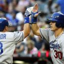 Los Angeles Dodgers' Matt Treanor (18) high-fives Jerry Sands (30) after Treanor's two-run home run during the second inning of a baseball game against the Arizona Diamondbacks, Monday, May 21, 2012, in Phoenix. (AP Photo/Ross D. Franklin)