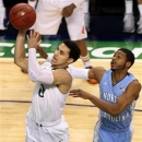 Miami's Shane Larkin makes a shot in front of North Carolina State's Dexter Strickland in the first half of an NCAA basketball game during the championship game of the ACC Tournament in Greensboro, N.C. on Sunday March 17, 2013. (AP Photo/Burlington Times-News, Al Drago)