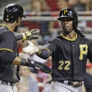 Pittsburgh Pirates' Andrew McCutchen (22) and Starling Marte slap hands with each other after they scored on a hit by Marlon Byrd off Cincinnati Reds starting pitcher Homer Bailey during the third inning of a baseball game, Friday, Sept. 27, 2013, in Cincinnati. (AP Photo/Al Behrman)