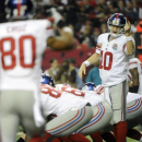 New York Giants quarterback Eli Manning (10) speaks to Giants wide receiver Victor Cruz (80) against the Atlanta Falcons during the first half of an NFL football game on Sunday, Dec. 16, 2012, in Atlanta. (AP Photo/John Amis)