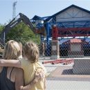 Omaha residents Mary Dilley and her daughter Jesse May watch as heavy equipment tears into the front of Rosenblatt Stadium, the former home of the NCAA baseball College World Series in Omaha, Neb., Wednesday, July 25, 2012. The stadium is being torn down to make room for a parking lot for the adjacent Henry Doorly Zoo. (AP Photo/Nati Harnik)
