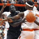 Cincinnati's David Nyarsuk passes the ball under pressure from Syracuse's C.J. Fair, Baye Moussa Keita, right, and Jerami Grant, left, during the first half of an NCAA college basketball game in Syracuse, N.Y., Monday, Jan. 21, 2013. (AP Photo/Kevin Rivoli)