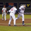 Minnesota Twins' Trevor Plouffe, right, is congratulated by third base coach Joe Vavra, wearing number 42 in honor of Jackie Robinson Day, after hitting a solo home run against Los Angeles Angels starting pitcher Joe Blanton during the fourth inning of a baseball game Monday, April 15, 2013, in Minneapolis. Los Angeles Angels third baseman Luis Jimenez is pictured at rear left. (AP Photo/Genevieve Ross)