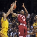 Indiana's Kevin Ferrell (11) gets off a shot over Minnesota's Andre Hollins, left, during the first half of an NCAA college basketball game, Tuesday, Feb. 26, 2013, in Minneapolis. Minnesota's Trevor Mbakwe is at right. (AP Photo/Tom Olmscheid)