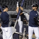 New York Yankees' Nick Swisher, right, and Russell Martin high-five during baseball practice Friday, Oct. 5, 2012, at Yankee Stadium in New York for the American League division series. (AP Photo/Bill Kostroun)