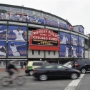 Traffic drives past Wrigley Field after the baseball game between the Milwaukee Brewers and Chicago Cubs was postponed due to inclement weather on Wednesday, April 10, 2013, in Chicago. (AP Photo/Jim Prisching)