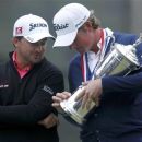 Webb Simpson (R) of the U.S. and runner-up, Northern Ireland's Graeme McDowell look at inscriptions on the U.S. Open Championship Trophy after Simpson won the 2012 U.S. Open golf tournament on the Lake Course at the Olympic Club in San Francisco, California June 17, 2012. REUTERS/Robert Galbraith