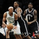 Boston Celtics forward Paul Pierce (34) passes the ball as Brooklyn Nets guard Joe Johnson (7) and forward Andray Blatche (0) defend in the first half of their preseason NBA basketball game at Barclays Center, Thursday, Oct. 18, 2012, in New York. (AP Photo/Kathy Willens)