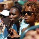 Venus Williams, center, watches her sister, Serena Williams, play Jelena Jankovic, of Serbia, during the singles final at the Family Circle Cup tennis tournament in Charleston, S.C., Sunday, April 7, 2013. Williams defeated Jankovic, 3-6, 6-0, 6-2, to win the Family Circle Cup. (AP Photo/Mic Smith)
