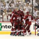 Phoenix Coyotes' Michal Rozsival (32), of the Czech Republic, Daymond Langkow (22) and Keith Yandle celebrate a goal by Taylor Pyatt, second from left, between Chicago Blackhawks' Jamal Mayers (22) and Niklas Hjalmarsson (4), of Sweden, during the second period in Game 1 of an NHL hockey Stanley Cup first-round playoff series, Thursday, April 12, 2012, in Glendale, Ariz. (AP Photo/Ross D. Franklin)