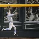 UCLA right fielder Eric Filia makes a leaping catch of a fly ball hit by Mississippi State's Nick Ammirati in the fifth inning of Game 1 in their NCAA College World Series baseball finals, Monday, June 24, 2013, in Omaha, Neb. (AP Photo/Francis Gardler)