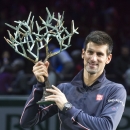 Novak Djokovic of Serbia, holds the trophy after he defeated Milos Raonic of Canada during their final match at the ATP World Tour Masters tennis tournament at Bercy stadium in Paris, France, Sunday, Nov. 2, 2014. Djokovic won 6-2, 6-3. (AP Photo/Michel Euler)