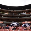 Fans sit in their seats as a light rain falls before a baseball game between the St. Louis Cardinals and the Kansas City Royals, Thursday, May 30, 2013, in St. Louis. Showers were expected to move through the area before the game. (AP Photo/Jeff Roberson)