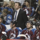 Colorado Avalanche head coach Joe Sacco, back, looks on as his players take a break during a time out against the Minnesota Wild in the second period of an NHL hockey game in Denver on Saturday, April 27, 2013. (AP Photo/David Zalubowski)