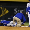 A trainer works on Toronto Blue Jays' Jose Reyes after he injured his leg while stealing second base during the sixth inning of a baseball game against the Kansas City Royals at Kauffman Stadium in Kansas City, Mo., Friday, April 12, 2013. Blue Jays second baseman Emilio Bonifacio (1) and Royals second baseman Elliot Johnson (23) stand to the side. (AP Photo/Orlin Wagner)