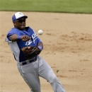 Kansas City Royals shortstop Miguel Tejada throws out Milwaukee Brewers' Carlos Gomez at first during the fourth inning of a spring training exhibition baseball game in Phoenix, Wednesday, March 27, 2013. (AP Photo/Chris Carlson)
