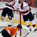 New Jersey Devils' Zach Parise, right, and David Clarkson, laying on the net, who scored what would be the game-winning goal celebrate during the third period in Game 2 of an NHL hockey Stanley Cup second-round playoff series with the Philadelphia Flyers, Tuesday, May 1, 2012, in Philadelphia. Flyers, Nick Grossmann kneels down in the crease. The Devils won 4-1 tying the best of seven series at 1-1.(AP Photo/Tom Mihalek)