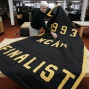 FILE - In this Feb. 6, 2007, file photo, Greg Kinney, archivist at the University of Michigan Bentley Historical Library unrolls the 1993 NCAA basketball tournament finalist banner being kept in storage in Ann Arbor, Mich. The banner was taken down from the university's Crisler Arena as part of self imposed sanctions following what the NCAA said was the largest financial scandal, and one of the worst of any kind, in the history of college athletics. Michigan's 10-year dissociation from Chris Webber, Maurice Taylor and Louis Bullock is over on May 8, 2013. The former Wolverines can formally reconnect with the school after one of the biggest scandals in NCAA history. Michigan athletic director Dave Brandon insisted the door is open. (AP Photo/Paul Sancya)
