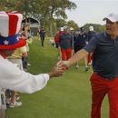 USA's Phil Mickelson hands fan Richard Atkins a pin after teeing off on the second hole at the Ryder Cup PGA golf tournament Wednesday, Sept. 26, 2012, at the Medinah Country Club in Medinah, Ill. (AP Photo/Charles Rex Arbogast)