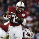 Stanford running back Stepfan Taylor breaks through Wisconsin defensive back Nate Hammon (14) during the second half of the Rose Bowl NCAA college football game, Tuesday, Jan. 1, 2013, in Pasadena, Calif. Stanford won 20-14. (AP Photo/Lenny Ignelzi)