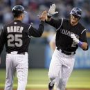 Colorado Rockies' Troy Tulowitzki (2) high-fives third base coach Gabe Bauer after Tulowitzki hit a solo home run off New York Mets starting pitcher Chris Schwinden in the first inning of their baseball game in Denver on Friday, April 27, 2012. (AP Photo/Joe Mahoney)