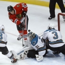 Chicago Blackhawks center Andrew Shaw (65) shoots and scores past San Jose Sharks goalie Antti Niemi and defenseman Douglas Murray (3) as center Joe Pavelski (8) watches during the second period of an NHL hockey game Friday, Feb. 15, 2013, in Chicago. (AP Photo/Charles Rex Arbogast)