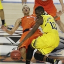 Syracuse's Michael Carter-Williams (1) falls to the court as Michigan's Tim Hardaway Jr. (10) vies for the ball during the second half of the NCAA Final Four tournament college basketball semifinal game Saturday, April 6, 2013, in Atlanta. (AP Photo/Chris O'Meara)