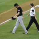 Pittsburgh Pirates relief pitcher Jason Grilli, left, walks off the field with a trainer during the ninth inning of a baseball game against the Washington Nationals, Monday, July 22, 2013, in Washington. The Pirates won 6-5. (AP Photo/Nick Wass)