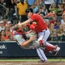 Atlanta Braves' Chipper Jones, right, is called out at home plate as he collides with Philadelphia Phillies catcher Erik Kratz, left, during the fourth inning of a baseball game on Friday, Aug. 31, 2012, at Turner Field in Atlanta. (AP Photo/Gregory Smith)