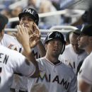 Miami Marlins' Giancarlo Stanton, second from left, and Donnie Murphy, center, celebrate with teammates after they scored on a double by Ricky Nolasco during the third inning of a baseball game against the Colorado Rockies, Tuesday, May 22, 2012, in Miami. (AP Photo/Wilfredo Lee)