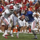 Oklahoma quarterback Blake Bell (10) scrambles against defenders Charles Tapper (91) and Geneo Grissom (85) during the annual Oklahoma spring intra-squad NCAA college football game in Norman, Okla., Saturday, April 13, 2013. (AP Photo/Sue Ogrocki)