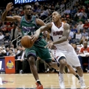 Atlanta Hawks' Jeff Teague, right, steps out of bounds while passing the ball past Milwaukee Bucks' Ekpe Udoh in the first quarter of an NBA basketball game, Wednesday, March 20, 2013, in Atlanta. (AP Photo/David Goldman)