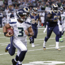Seattle Seahawks quarterback Russell Wilson (3) rushes against St. Louis Rams defense during the first half of an NFL football game, Monday, Oct. 28, 2013, in St. Louis. (AP Photo/Tom Gannam)