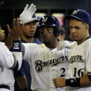 Milwaukee Brewers' Rickie Weeks is congratulated in the dugout after hitting a home run during the eighth inning of a baseball game against the Chicago Cubs Tuesday, June 25, 2013, in Milwaukee. The home run was Weeks' second in the game. (AP Photo/Morry Gash)