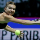 Romania's Simona Halep reaches for a backhand return to Serena Williams of the U.S. during their singles final at the WTA tennis finals in Singapore, Sunday, Oct. 26, 2014. (AP Photo/Mark Baker)