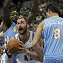 Minnesota Timberwolves' Kevin Love, center, eyes the basket between Denver Nuggets' Danilo Gallinari, right, of Italy, and another defender in the first half of an NBA basketball game on Wednesday, Nov. 21, 2012, in St. Paul. it was Love's return to the lineup for the first time in regular season play after suffering a broken hand. (AP Photo/Jim Mone)