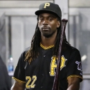 Pittsburgh Pirates' Andrew McCutchen tosses a bat as he walks through the dugout during the eighth inning of a baseball game against the San Diego Padres in Pittsburgh, Friday, Aug. 8, 2014. McCutchen is recovering from a rib injury and did not play. The Pirates won 2-1. (AP Photo/Gene J. Puskar)