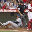 New York Yankees' Derek Jeter, left, scores past Los Angeles Angels catcher Bobby Wilson on s a single by Alex Rodriguez as home plate umpire Paul Schrieber looks on during the first inning of a baseball game in Anaheim, Calif., Monday, May 28, 2012. (AP Photo/Chris Carlson)