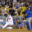 Los Angeles Dodgers' Yasiel Puig, left, reacts as he pops out to end the their baseball game as Chicago Cubs catcher Dioner Navarro looks on, Tuesday, Aug. 27, 2013, in Los Angeles. The Cubs won 3-2. (AP Photo/Mark J. Terrill)